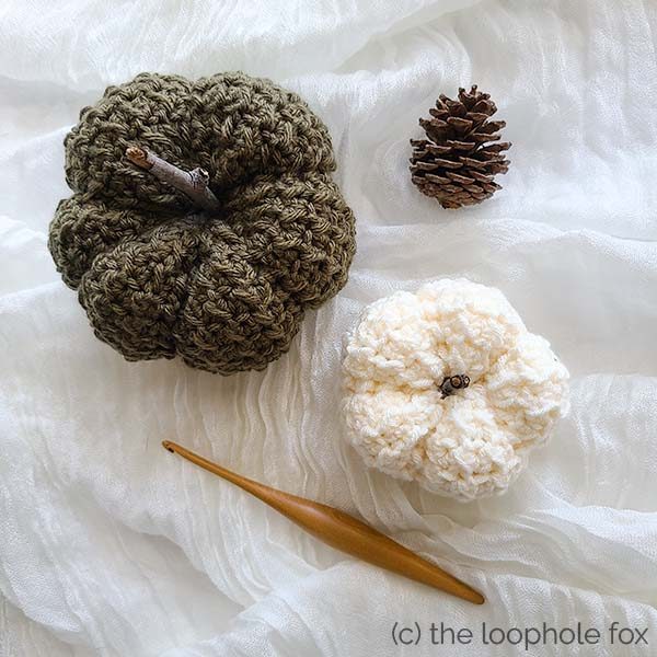 This image shows two pumpkins, one green and one white, from the top down. Both are crocheted using the even moss stitch.