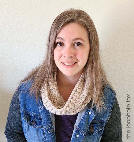 The crochet infinity cowl pattern is shown finished, worn by a woman with a denim jacket.