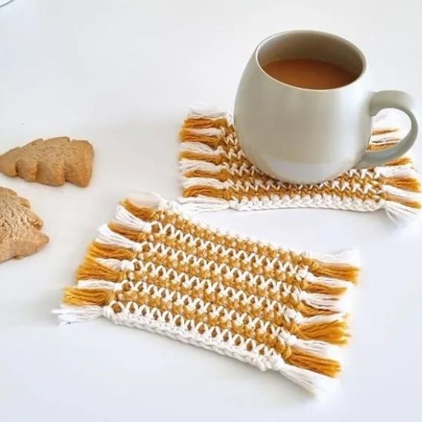 This image shows the Tea Spa Crochet Mug Rug by My Crochet Space. This super cute crochet project is a rectangle  mug rug (or coaster), designed in stripes. It is shown on a white background with cookies and a cup of tea.