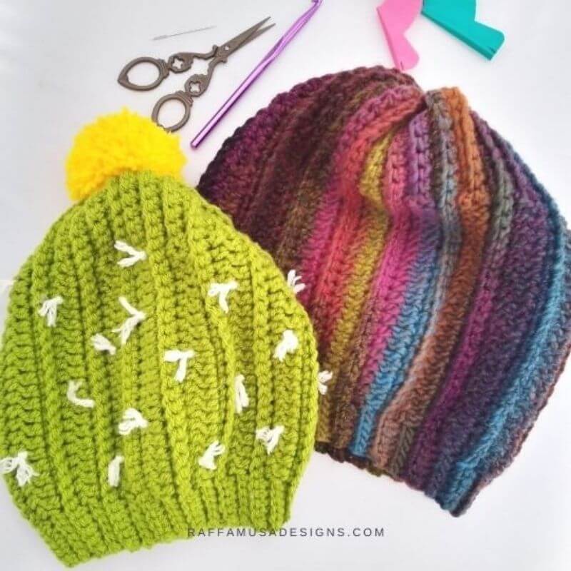 This image shows the Cactus Beanie, one of the free crochet hat patterns in this round up, laid flat on a white background. Two versions are shown. One is the "cactus" beanie and the other is made in self striping yarn.
