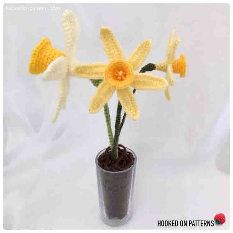 This image is of the Spring Daffodils. The image shows 3 of the crochet daffodils in a vase with a white background.