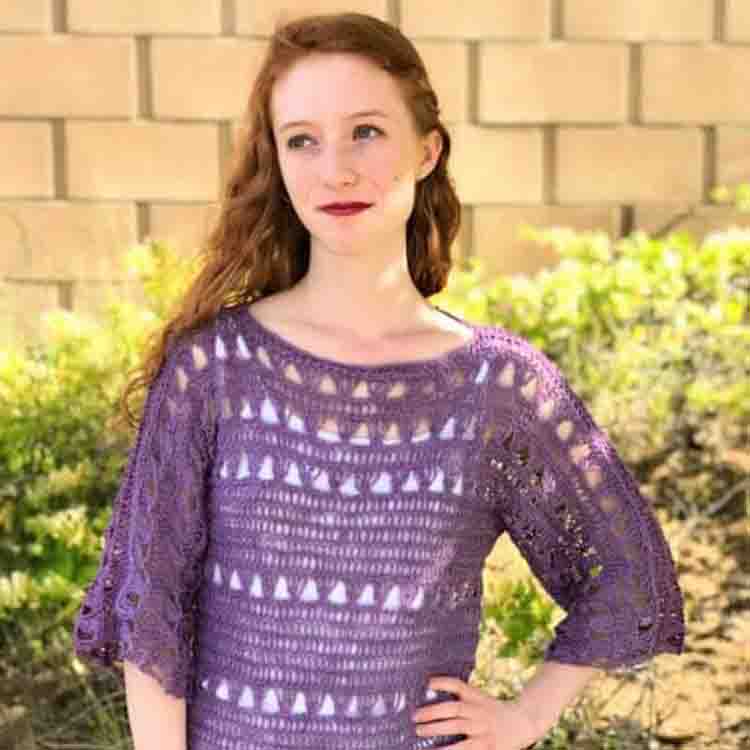 This image is of the Shelby Top, one of the crochet projects for spring. This image shows a woman wearing the crocheted top made in a deep lavender color.