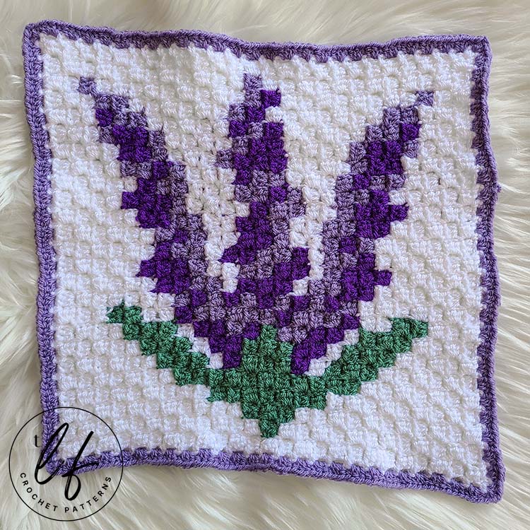 This image shows the Lavender c2c blanket square laying flat on a fluffy white background. 