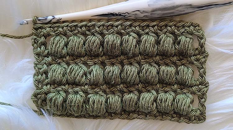 This image shows a swatch created with the closed crochet puff stitch with a row of single crochet worked in between. This is the crochet stitch we will now be learning.