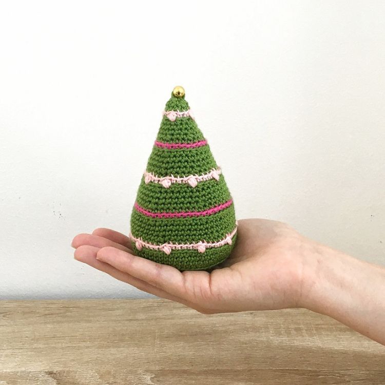 This image shows the next quick crochet gifts, which is the Tiny Lights Christmas Tree as described above. The image shows the tree sitting on the palm of a hand with a white background.