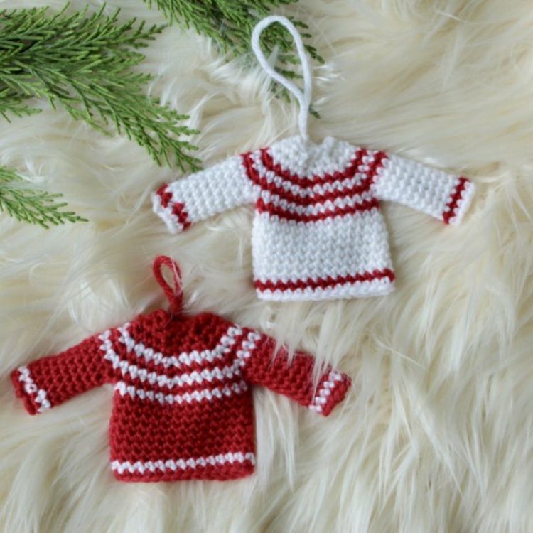 This image shows the next pattern, which is the Mini Xmas Jumpers as described above. The image shows two of the ornaments laying flat on a fluffy white background.