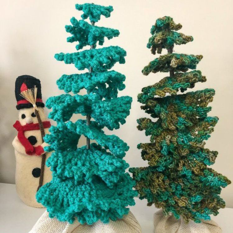 This image shows the next quick crochet gifts, which is the Evergreen Table Top Trees as described above. The image shows the trees sitting on a table top with a little snowman in the background.