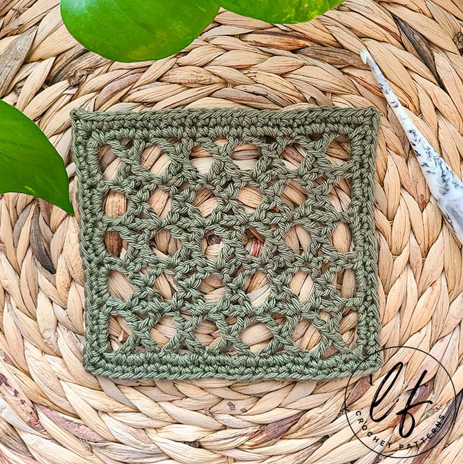 This image shows a swatch crocheted with the Treble Cross Stitch, also known as the K Stitch or Crossed Treble Crochet. The swatch is made in an olive green yarn and set on a jute placemat.